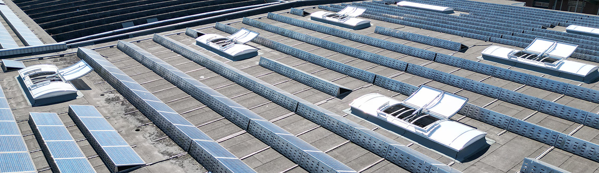 Detail der Lagerhalle von Expo-Börse in Quakenbrück: Auf dem Dach befinden sich neben den Solarzellen der PV-Anlage nach erfolgreicher Sanierung insgesamt 500 Meter Lichtband und Rauchabzugsklappen von ESSERTEC.